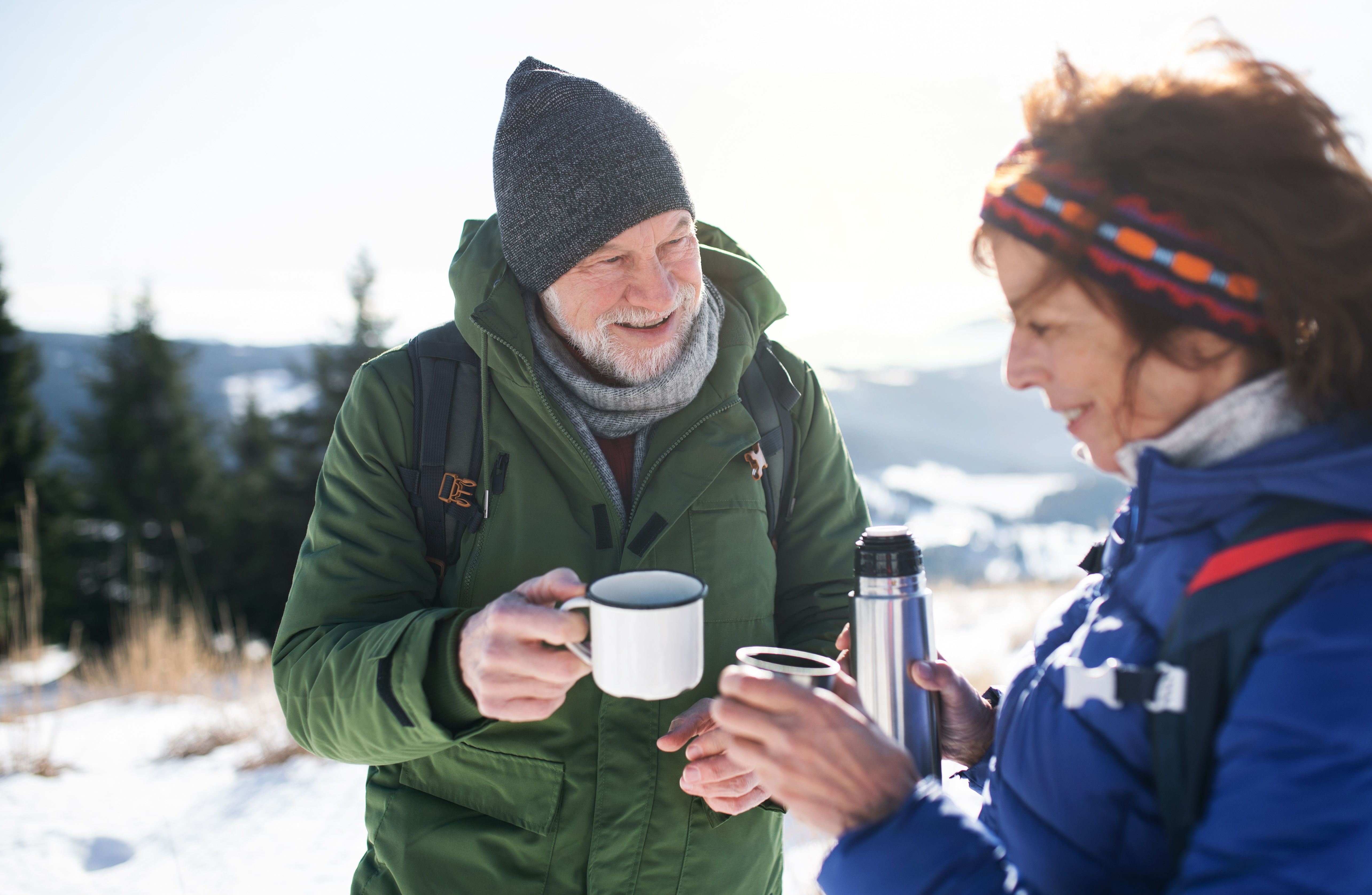 Escursionisti con thermos durante una pausa nella neve in Trentino