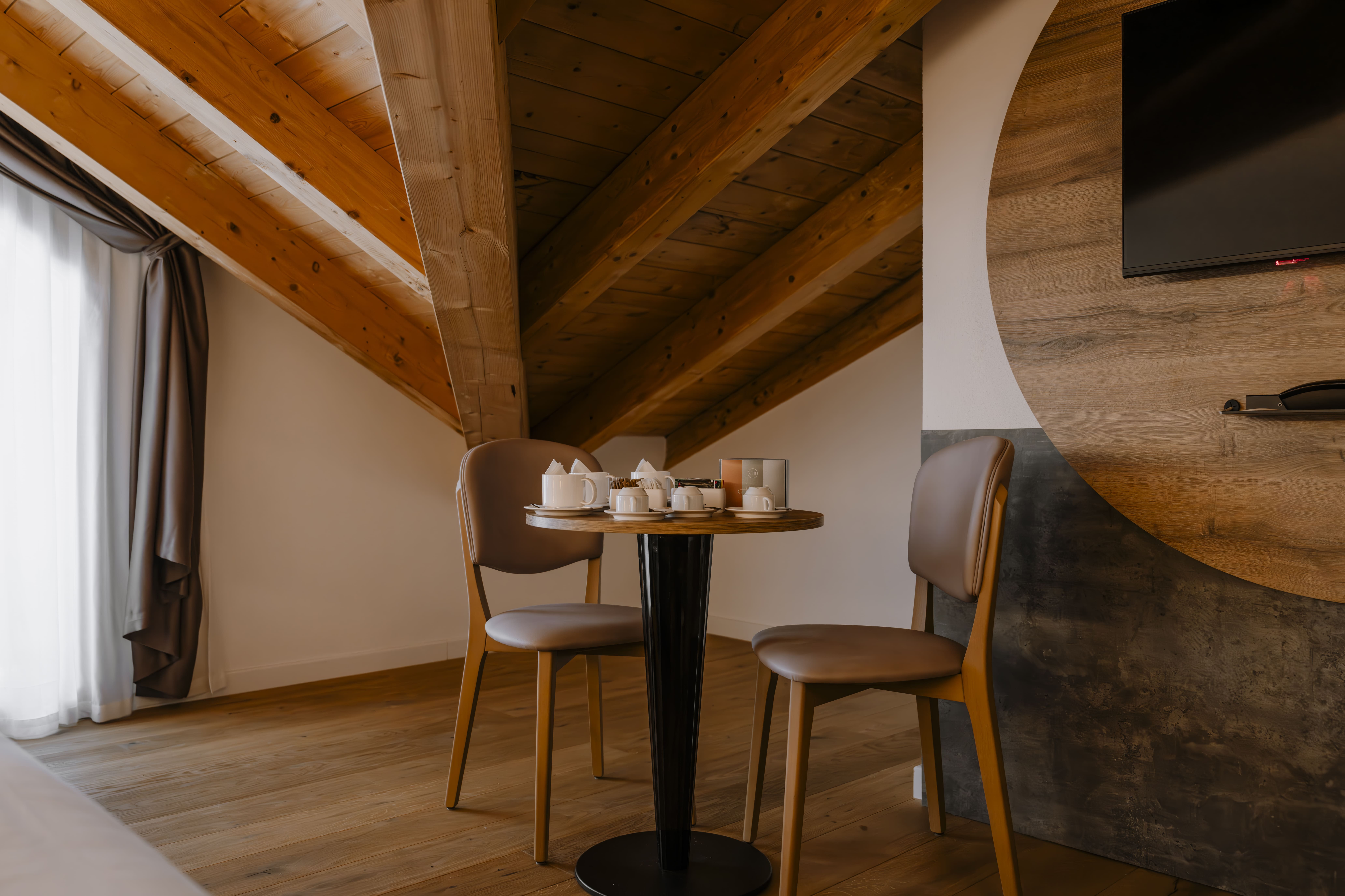 Suite mansardata con travi in legno, hotel Armon Greenblu in Trentino